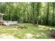 Spacious backyard with a fire pit, wooden deck, and lush greenery, offering a serene outdoor space at 589 John Mitchell Rd, Youngsville, NC 27596