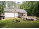 Lush backyard featuring a wooden deck, screened porch, and a cozy fire pit area for outdoor enjoyment at 589 John Mitchell Rd, Youngsville, NC 27596