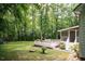 Expansive backyard featuring a wooden deck, screened porch, and lush greenery, perfect for outdoor entertaining and relaxation at 589 John Mitchell Rd, Youngsville, NC 27596
