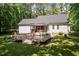 Backyard with a spacious deck, screened porch, and fire pit surrounded by lush greenery creating a private outdoor space at 589 John Mitchell Rd, Youngsville, NC 27596