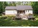 Expansive backyard featuring a wooden deck, screened porch and an inviting fire pit area for outdoor enjoyment at 589 John Mitchell Rd, Youngsville, NC 27596