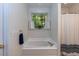Bright bathroom featuring a tub with a view to the outdoors at 589 John Mitchell Rd, Youngsville, NC 27596