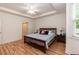 Well lit bedroom with wood floors, ceiling fan and ensuite bath at 589 John Mitchell Rd, Youngsville, NC 27596