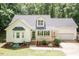 Inviting home exterior featuring a covered porch, attached garage, manicured landscaping, and an ample driveway at 589 John Mitchell Rd, Youngsville, NC 27596