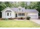 Charming home with a welcoming front porch, blue shutters, and a well-maintained lawn surrounded by lush greenery at 589 John Mitchell Rd, Youngsville, NC 27596
