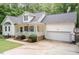 Inviting home exterior featuring a covered porch, attached garage, manicured landscaping, and an ample driveway at 589 John Mitchell Rd, Youngsville, NC 27596