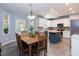 Bright eat-in kitchen with white cabinets, stainless appliances, island, and gray tile flooring at 589 John Mitchell Rd, Youngsville, NC 27596