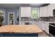 Bright kitchen with white cabinets, stainless steel appliances, and a butcher block island at 589 John Mitchell Rd, Youngsville, NC 27596