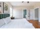 Comfortable bedroom with hardwood floors, white bedding, and ensuite bathroom entrance at 595 E Cabarrus St, Raleigh, NC 27601