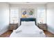 Bright bedroom featuring two windows, modern artwork, and plush white bedding at 595 E Cabarrus St, Raleigh, NC 27601