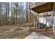 View of a backyard and a wooden deck supported by beams, with some AC units and some forest views at 629 Newlyn Dr, Raleigh, NC 27606