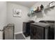 Modern laundry room with a black washer and dryer, open shelving, and gray walls at 629 Newlyn Dr, Raleigh, NC 27606