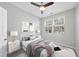 Comfortable bedroom with neutral colors, ceiling fan, and bright natural light from the double windows at 684 Wickham Ridge Rd, Apex, NC 27539