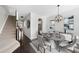 Elegant dining room with modern light fixture, stylish furnishings, and staircase for a sophisticated ambiance at 684 Wickham Ridge Rd, Apex, NC 27539