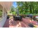 Back deck with outdoor furniture and a grill surrounded by green trees at 808 Ravenwood Dr, Raleigh, NC 27606