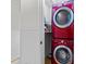 Small laundry room featuring stacked red washer and dryer units at 808 Ravenwood Dr, Raleigh, NC 27606