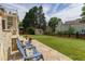 Spacious backyard featuring a stone patio, verdant lawn, and exterior landscaping at 8913 Walking Stick Trl, Raleigh, NC 27615