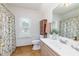 Charming bathroom with patterned curtain, wooden cabinet, window and sink with a big mirror at 8913 Walking Stick Trl, Raleigh, NC 27615
