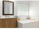 Bathroom vanity with a large soaking tub and natural lighting at 8913 Walking Stick Trl, Raleigh, NC 27615