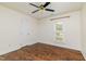 Spacious bedroom with dark wood floors, a ceiling fan, natural light and white walls at 8913 Walking Stick Trl, Raleigh, NC 27615