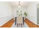 Bright dining room featuring hardwood floors, rug, modern light fixture, and view to the yard at 8913 Walking Stick Trl, Raleigh, NC 27615