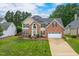 Two-story home with a well-manicured lawn, brick and siding exterior, solar panels and a two car garage at 8913 Walking Stick Trl, Raleigh, NC 27615