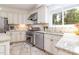 Updated kitchen featuring white cabinets, granite countertops, stainless steel appliances, and tile flooring at 8913 Walking Stick Trl, Raleigh, NC 27615