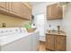 Organized laundry room with washer, dryer, cabinets, sink, window and lots of storage space at 8913 Walking Stick Trl, Raleigh, NC 27615