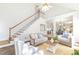 Bright living room with a staircase, hardwood floors, and comfortable furniture arrangement at 8913 Walking Stick Trl, Raleigh, NC 27615
