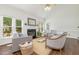 Open concept living room with a fireplace, hardwood floors, large windows and neutral paint at 8913 Walking Stick Trl, Raleigh, NC 27615