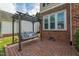 Brick patio featuring a porch swing with cushions and floral pillows next to the brick exterior of the home at 8913 Walking Stick Trl, Raleigh, NC 27615