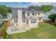 Backyard view of home featuring a stone patio and solar panels at 8913 Walking Stick Trl, Raleigh, NC 27615