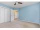 Bedroom with blue walls, neutral carpet, white closet doors, and lots of natural light at 9308 Carisbrook Ct, Raleigh, NC 27615