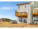 Rear exterior view of a two-story home featuring a wooden deck, outdoor seating, and sliding glass doors at 10011 Secluded Gdn Dr # 169, Apex, NC 27523