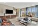 Bright living room with large windows, modern furniture, and stylish decor with access to an outdoor deck at 10011 Secluded Gdn Dr # 169, Apex, NC 27523