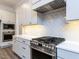 Modern kitchen with stainless steel stove, range hood, and tiled backsplash at 1011 Coldspring Circle, Durham, NC 27705