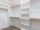 Bright walk-in closet featuring custom shelving, wooden rods and hardwood flooring at 1011 Coldspring Circle, Durham, NC 27705