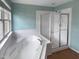 Bathroom featuring a large tub with a separate shower area and natural light from a nearby window at 102 Darley Dale Loop, Apex, NC 27502