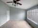 Spacious bedroom with a ceiling fan and a large window, offering ample natural light at 102 Darley Dale Loop, Apex, NC 27502