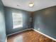 Bedroom with a window letting in natural light and beautiful hardwood flooring at 102 Darley Dale Loop, Apex, NC 27502