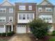 Charming multi-level townhouse with stone accents, attached garage, and well-maintained landscaping at 102 Darley Dale Loop, Apex, NC 27502