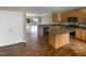 Open-concept kitchen featuring an island, wooden cabinets, and a seamless transition to the living area at 102 Darley Dale Loop, Apex, NC 27502