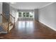 Empty living room showcasing hardwood floors, neutral paint, and plenty of natural light at 102 Darley Dale Loop, Apex, NC 27502