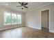 Bright bedroom featuring wood floors, a ceiling fan, and large windows with natural light at 1027 Coldspring Circle, Durham, NC 27705