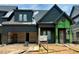 New home construction featuring dark siding, a two-car garage and covered porch with modern design elements at 1027 Coldspring Circle, Durham, NC 27705
