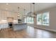 Open concept kitchen with white cabinets, gray island, and a modern light fixture at 1027 Coldspring Circle, Durham, NC 27705