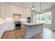 Stylish kitchen features stainless steel appliances, white cabinetry, and gray island at 1027 Coldspring Circle, Durham, NC 27705