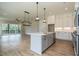Open concept kitchen with gray island, white cabinets, and stainless steel appliances at 1027 Coldspring Circle, Durham, NC 27705