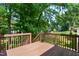 Large backyard with a brown wooden deck and lush trees at 106 Gumdrop Path, Apex, NC 27502