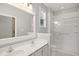 A well-lit bathroom features a double sink vanity, glass-enclosed shower, and a bright window at 106 Gumdrop Path, Apex, NC 27502